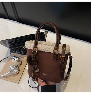 Détail du sac seau en daim avec bordure en similicuir et breloques décoratives en perles