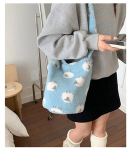 Détail du sac seau bleu clair en peluche avec motifs de moutons et bandoulière large