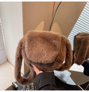 Detailed view of the soft brown faux fur handbag displayed in a cozy interior setting