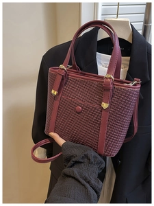 Dettaglio della borsa tote intrecciata rosso vino con trama premium e tracolla in pelle