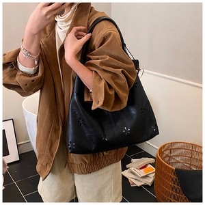 Gros plan sur un sac cabas noir en cuir PU mat avec détails ajourés en forme d'étoile