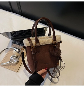 Détail du sac seau en suédine avec bordure en peau lainée et breloque pompon doux