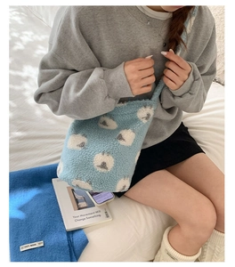 Gros plan sur le sac seau en polaire bleu clair avec motifs moutons et bandoulière large