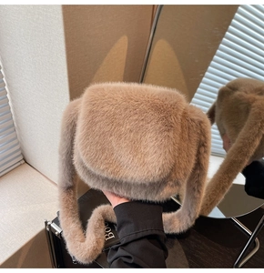Detailed view of plush faux fur texture and flap closure on light brown shoulder bag