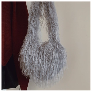 Détail du sac à épaule en fausse fourrure grise avec texture douce et bandoulière intégrée