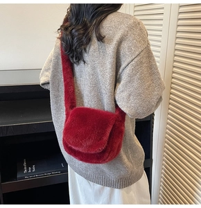 Detail view of burgundy plush crossbody bag showing the soft texture and shoulder strap
