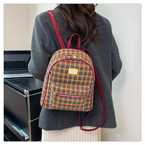 Mannequin portant un sac à dos en tweed coloré avec bretelles rouges et plaque dorée