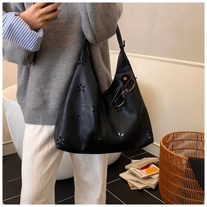 Détail du motif ajouré au laser sur le grand sac hobo noir idéal pour le travail quotidien