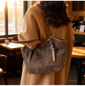 Dettaglio della borsa tote in pelle scamosciata leopardata con tracolla in pelle marrone