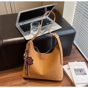 Close-up of brown faux leather tote bag on a bench featuring 'FASHION & BAGS' logo