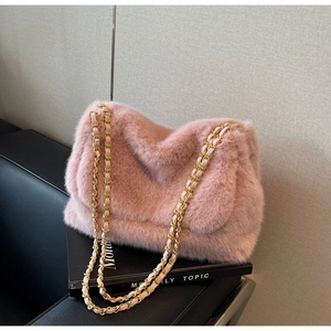 Détail du sac à rabat en peluche rose avec chaîne dorée et texture douce et duveteuse