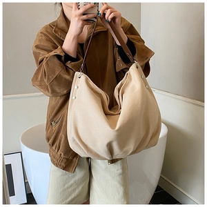 Detail of minimalist canvas tote with premium brown leather strap and metal rivets
