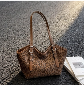 Dettaglio della borsa tote leopardata con spalline sottili e fibbie metalliche