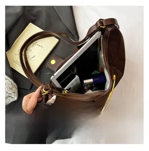 Spacious interior of a dark brown suede tote bag showing storage for tablet and makeup