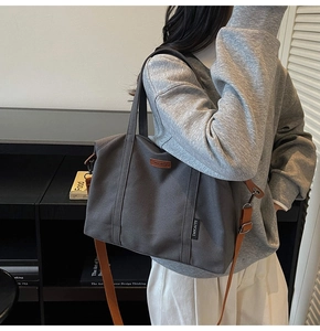 Detail of dark grey canvas tote with leather straps and spacious interior for daily commute