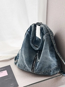 Deep blue washed denim crossbody hobo bag with vintage metal zipper and drawstring