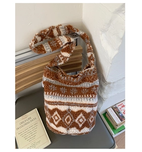 Détail du sac seau pelucheux à pois avec motifs ethniques et large bandoulière sur banc
