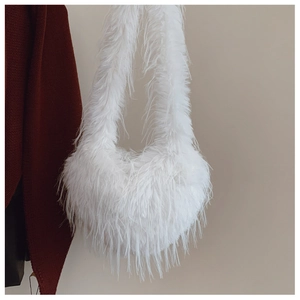Gros plan d'un sac à main en peluche blanche en forme de cœur avec texture en fausse fourrure