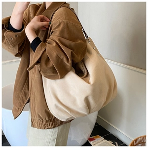 Close-up of cream canvas tote bag with slim dark shoulder strap and metal buckle