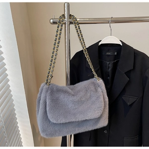 Détail du sac bandoulière en peluche grise avec chaîne dorée et texture douce en fourrure