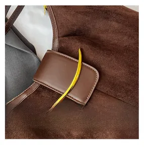 Detail of brown suede tote bag with golden crescent buckle and refined stitching