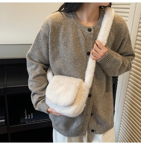 Detail of white plush crossbody bag with soft faux fur texture and matching strap
