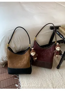 Dettaglio delle borse a secchiello vintage in pelle scamosciata bicolore con orsetti