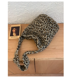 Gros plan du sac seau à motif léopard en fausse fourrure douce et bandoulière large