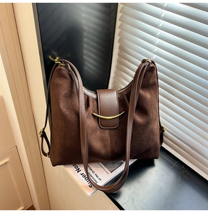 Detail of dark brown suede Hobo bag with elegant gold metal hook clasp and double straps