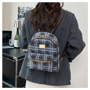 Détails d'un sac à dos vintage à carreaux avec motif d'étoiles et garniture en cuir brun
