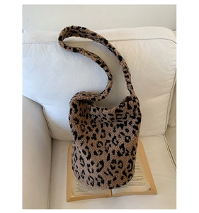 Gros plan du sac seau en peluche léopard avec texture douce sur un livre vintage