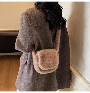Detail of plush faux fur crossbody bag in beige showing soft texture on wool coat
