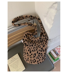 Détail du sac seau pelucheux à motif léopard en fausse fourrure douce sur une chaise