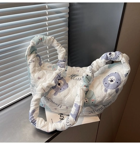 Dettaglio della borsa trapuntata bianca con orsetti viola e manici arricciati
