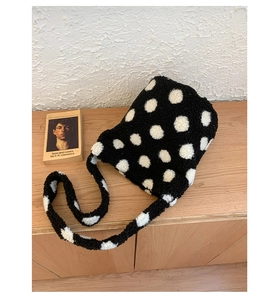 Détail de la texture pelucheuse douce et du motif à pois blanc sur le sac seau