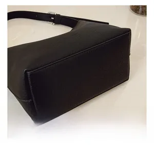 Detailed view of black pebbled leather tote bag base with fine stitching and silver hardware