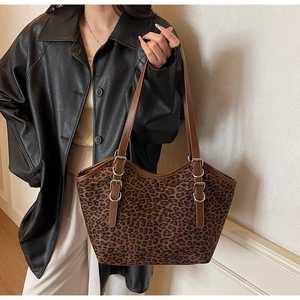 Dettaglio della borsa tote leopardata con tracolla in pelle marrone su modella