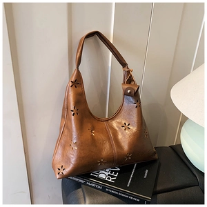 Gros plan du sac hobo marron vintage avec motifs floraux découpés au laser