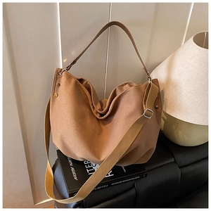 Detail of soft brown canvas tote bag texture with leather strap on vintage background