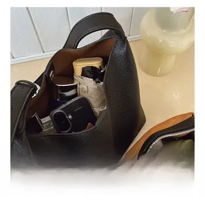 Interior view showing the large capacity and pebble leather texture of the black bucket bag