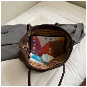 Interior view of brown tote bag showing large capacity for tablet and cosmetics