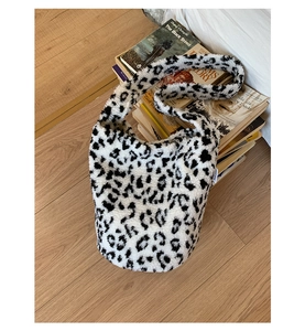 Détail du sac seau en peluche léopard avec fausse fourrure douce et étiquette sur livres