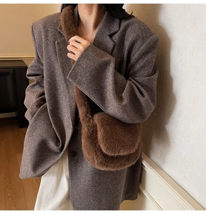 Brown plush crossbody bag styled with a grey herringbone blazer and white trousers