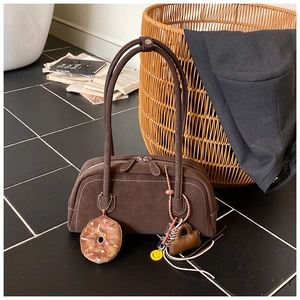 Detailed view of brown vintage Boston bag with contrast stitching and decorative charms