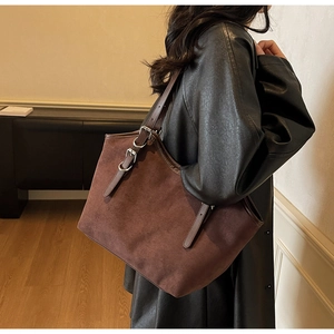 Dettaglio della borsa tote retrò in pelle scamosciata con spalline regolabili in cuoio