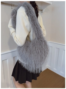 Détail du sac à bandoulière en fausse fourrure grise porté par un mannequin en intérieur