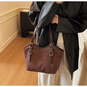 Dettaglio della borsa tote in pelle scamosciata marrone con cinturini regolabili