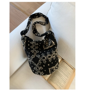 Gros plan du sac seau pelucheux à pois noirs et blancs sur un canapé confortable