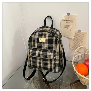 Détail de la texture en tweed à carreaux vintage et fermeture éclair en métal doré du sac