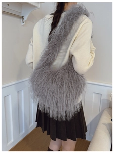 Modèle portant un grand sac à main en peluche grise en forme de cœur pour l'hiver
